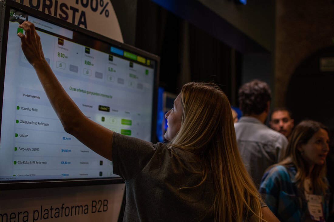 Equipo de Agrired mostrando la plataforma en pantalla a un visitante